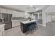 This kitchen features white cabinets, stainless steel appliances, an island with seating and gray wood floors at 9090 Josepine St, Pahrump, NV 89048