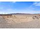 Desert land in Nevada with distant mountains, a fence, and building materials at 9090 Josepine St, Pahrump, NV 89048