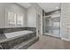 This main bathroom features a soaking tub, glass shower and gray marble tile at 9090 Josepine St, Pahrump, NV 89048