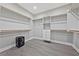 This walk-in closet features built in shelving and gray wood floors at 9090 Josepine St, Pahrump, NV 89048