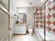 Bathroom featuring a patterned bathtub shower combo, single vanity, and cream tiled floors at 9101 Alta Dr # 18, Las Vegas, NV 89145