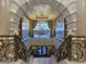 Grand staircase with decorative iron railings and a stunning chandelier, showcasing elegance and architectural detail at 9101 Alta Dr # 18, Las Vegas, NV 89145
