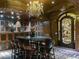 Opulent wine cellar with custom wood cabinetry, a statement chandelier, and a tasting table for gatherings at 9101 Alta Dr # 18, Las Vegas, NV 89145