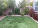 Private backyard space with lush landscaping, turf, and brick perimeter, perfect for outdoor enjoyment at 9343 Sully Ave, Las Vegas, NV 89149