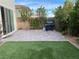 Outdoor patio area with turf, pavers and built-in grill, an ideal setting for entertaining at 9343 Sully Ave, Las Vegas, NV 89149