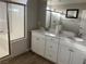 A bright bathroom featuring a double sink vanity, a glass enclosed shower and luxury vinyl plank flooring at 9343 Sully Ave, Las Vegas, NV 89149
