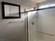 A bright bathroom featuring a modern glass enclosed shower and a framed mirror at 9343 Sully Ave, Las Vegas, NV 89149