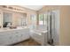 Bathroom features a double sink vanity, soaking tub, and glass shower at 9446 Baltinglass St, Las Vegas, NV 89123