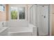 Clean bathroom shows soaking tub and glass-enclosed shower, plus a window at 9446 Baltinglass St, Las Vegas, NV 89123