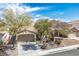 Charming single-story home with a two-car garage and desert landscaping under a bright blue, partly cloudy sky at 9446 Baltinglass St, Las Vegas, NV 89123