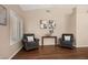 A cozy living room showcases two armchairs, neutral walls, and plantation shutters at 9446 Baltinglass St, Las Vegas, NV 89123