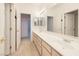Bathroom featuring double sinks, a large mirror, updated fixtures, and neutral tiling throughout at 979 Evening Dew Dr, Las Vegas, NV 89110