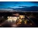 Striking home exterior at night showcasing a three-car garage and professionally landscaped front yard with landscape lighting at 979 Evening Dew Dr, Las Vegas, NV 89110