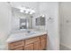 Well-lit bathroom featuring wooden cabinets and a spacious white countertop with sink and a large mirror at 10100 Jacob Pl # 204, Las Vegas, NV 89144