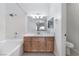 Bright bathroom featuring a tub, a shower, and a wood vanity with light fixtures at 10100 Jacob Pl # 204, Las Vegas, NV 89144