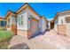 Side view showcases brick accents, a two-car garage, a walkway to the front door, and low-maintenance desert landscaping at 1012 Terron Allen Ave, North Las Vegas, NV 89031