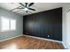Contemporary bedroom with a decorative black accent wall, wood floors, and natural light at 1088 Casady Hollow Ave, Henderson, NV 89012
