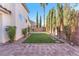 Beautifully landscaped backyard featuring lush artificial turf and brick pavers at 10955 Sospel Pl, Las Vegas, NV 89141