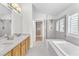 Modern bathroom with double sinks, marble countertops, separate shower and soaking tub at 10955 Sospel Pl, Las Vegas, NV 89141