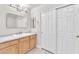 Bright bathroom with wood cabinets, large mirror, and stylish lighting fixtures at 10955 Sospel Pl, Las Vegas, NV 89141