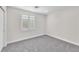 Bright bedroom with a large window featuring plantation shutters and neutral carpeting at 10955 Sospel Pl, Las Vegas, NV 89141