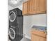 Efficient laundry room with stacked washer/dryer and ample cabinet space at 10955 Sospel Pl, Las Vegas, NV 89141