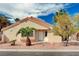 Inviting single-story home featuring a white front door, manicured yard, and mature landscaping at 1645 Indian Cove Ln, Las Vegas, NV 89128
