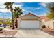 Attached garage with a white door and a concrete driveway in front of a charming home with palm trees at 1645 Indian Cove Ln, Las Vegas, NV 89128
