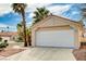 Attached garage with a white door and a concrete driveway in front of a charming home at 1645 Indian Cove Ln, Las Vegas, NV 89128