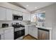 Bright kitchen features stainless steel appliances, quartz counters, white subway tile, and lots of natural light at 1645 Indian Cove Ln, Las Vegas, NV 89128