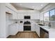 Well-lit kitchen with white cabinets, stainless steel appliances, and tile flooring at 1645 Indian Cove Ln, Las Vegas, NV 89128