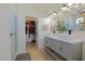 Bathroom with double vanity, white countertop, black fixtures, and a large walk in closet at 1660 W Princeton Cir, Pahrump, NV 89060