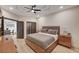 Cozy bedroom featuring a tray ceiling, ceiling fan, and ensuite bathroom at 167 Ebb Tide Cir, Las Vegas, NV 89123