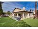 Rear exterior featuring a large backyard, outdoor kitchen, and grassy lawn at 167 Ebb Tide Cir, Las Vegas, NV 89123