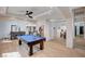 Bright game room boasts a pool table, wood floors and is connected to a dining area with view into another living area at 167 Ebb Tide Cir, Las Vegas, NV 89123