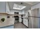 Modern kitchen with stainless steel appliances, bright skylight, and stylish backsplash at 1701 E Katie Ave # 51, Las Vegas, NV 89119