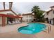 Community pool with lounge chairs near the buildings with red tile roofs and brick pillars on a cloudy day at 1701 E Katie Ave # 51, Las Vegas, NV 89119