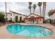 Community pool with lounge chairs and buildings with red tile roofs and palm trees on a cloudy day at 1701 E Katie Ave # 51, Las Vegas, NV 89119