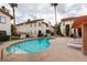 Community pool with lounge chairs surrounded by buildings with red tile roofs and palm trees on a cloudy day at 1701 E Katie Ave # 51, Las Vegas, NV 89119
