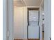 A white, stacked washer and dryer unit are conveniently located near a door, maximizing space at 1701 E Katie Ave # 68, Las Vegas, NV 89119