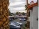 View of the parking lot with several parked cars, palm trees, and mountains in the background at 1701 E Katie Ave # 68, Las Vegas, NV 89119