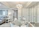 Dining area with glass table, white chairs, and chandelier, complemented by mirrored wall and seamless access to living areas at 1701 E Katie Ave # 9, Las Vegas, NV 89119