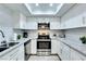 Modern kitchen with white cabinetry, stainless steel appliances, and granite countertops with recessed lighting at 1701 E Katie Ave # 9, Las Vegas, NV 89119