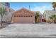 Single Gathering home featuring a two-car garage with a wide concrete driveway and desert landscaping at 1951 Raspberry Hill Rd, Las Vegas, NV 89142