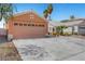 Single Gathering home featuring a two-car garage with a wide concrete driveway and desert landscaping at 1951 Raspberry Hill Rd, Las Vegas, NV 89142
