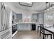 Well-lit kitchen features gray cabinets, stainless steel appliances, and a breakfast table, with wood flooring at 1951 Raspberry Hill Rd, Las Vegas, NV 89142