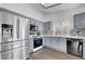 Updated kitchen featuring stainless steel appliances, grey cabinets, and bright white countertops at 1951 Raspberry Hill Rd, Las Vegas, NV 89142