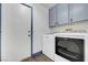 Laundry room with light blue cabinets, washer and dryer and laminate flooring at 1951 Raspberry Hill Rd, Las Vegas, NV 89142