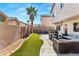 A backyard showing a patio with outdoor seating, artificial turf, palm tree and block wall fence at 232 Dog Leg Dr, Las Vegas, NV 89148