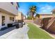 A backyard featuring a patio with outdoor seating, artificial turf, and a palm tree at 232 Dog Leg Dr, Las Vegas, NV 89148